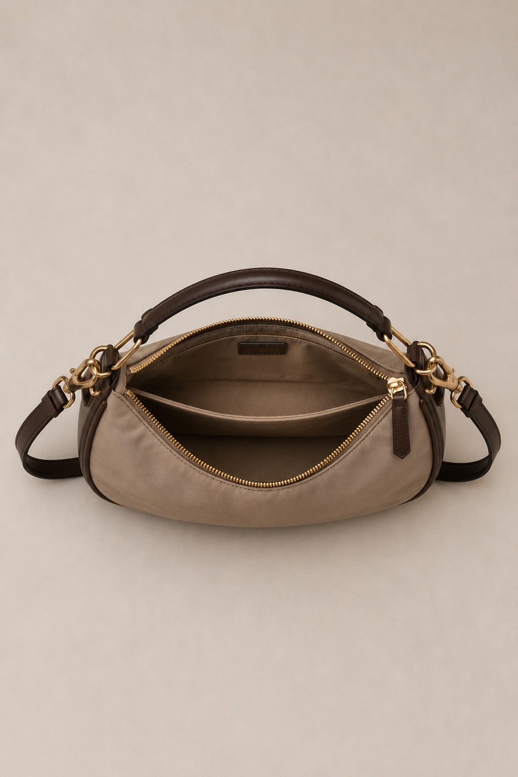 The Lumen crossbody open from above, showing the curved zip opening and the nylon interior.