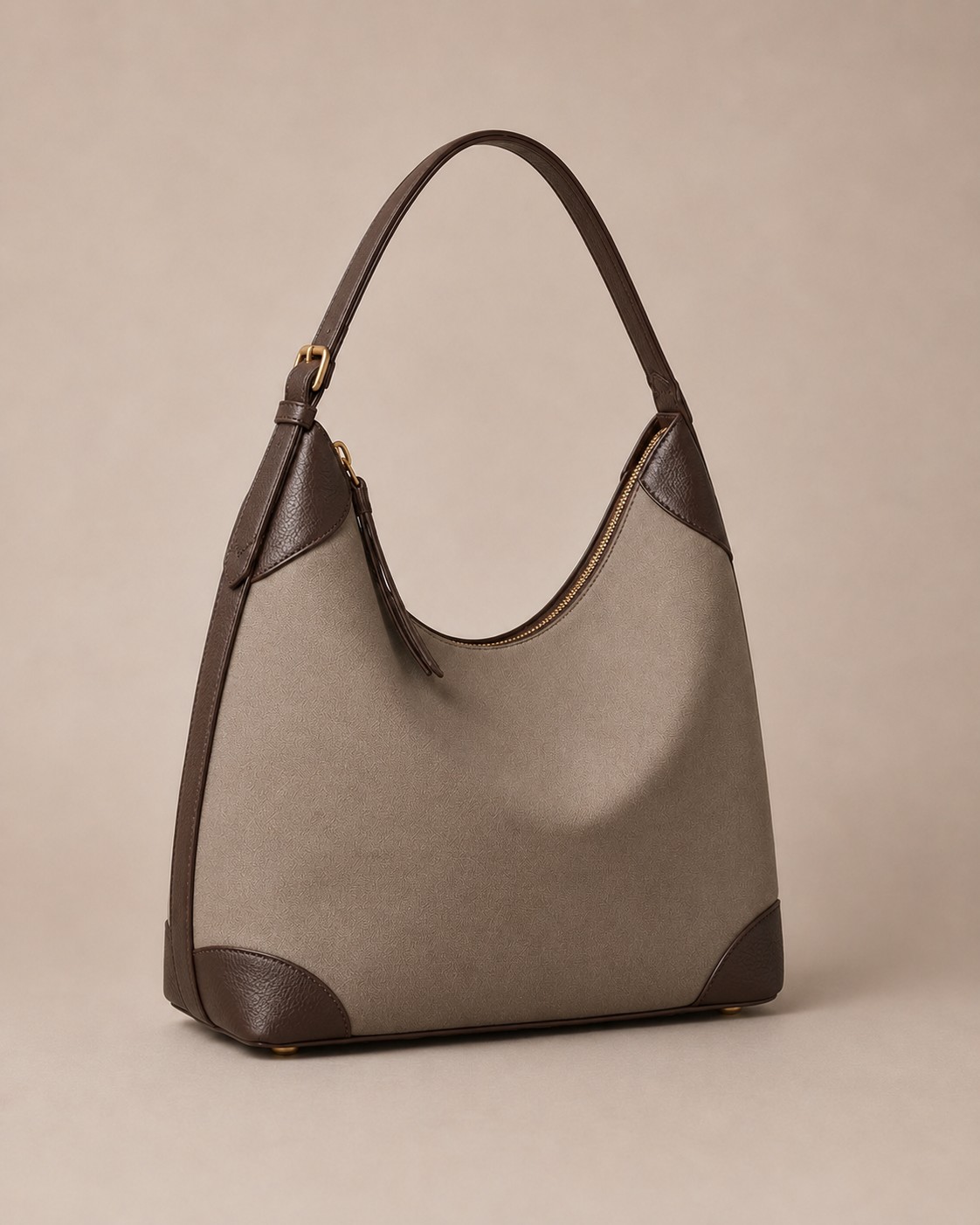 The Aria shoulder bag in taupe calfskin with a brass turn-lock and adjustable strap.